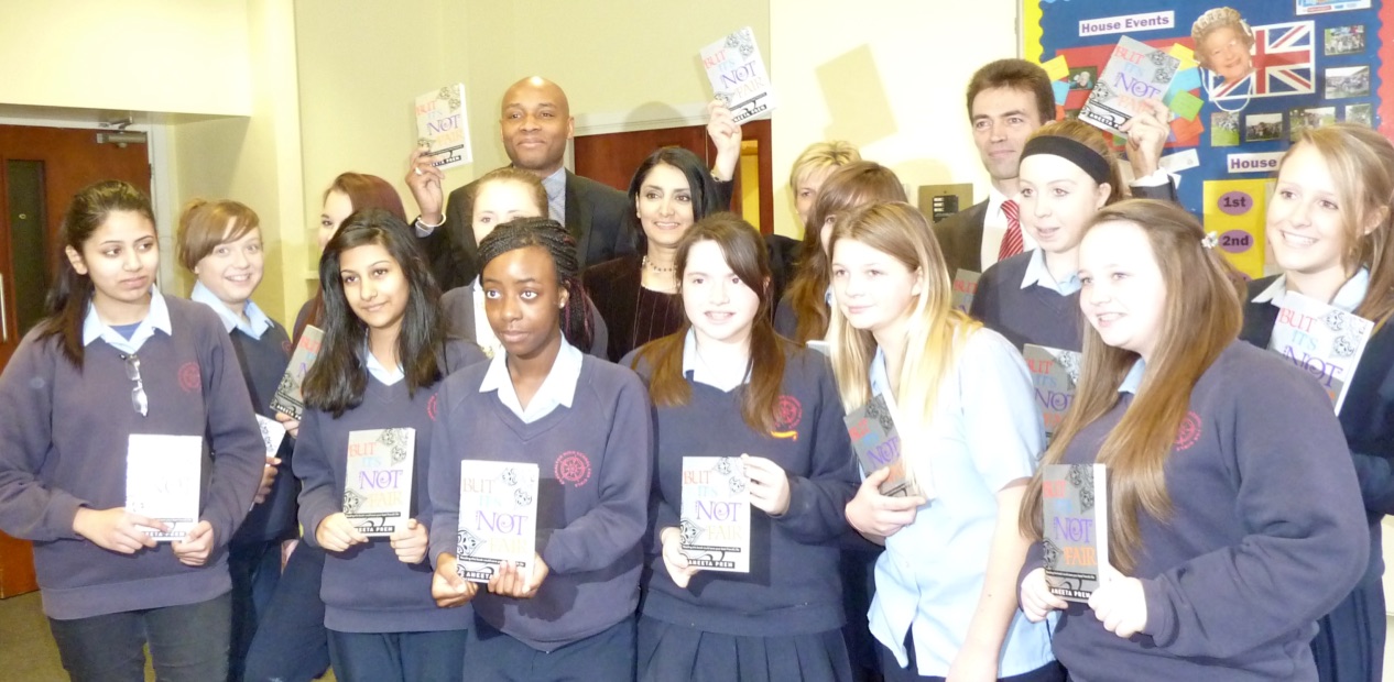 Pupils and school staff holding the original edition of But It's Not Fair
