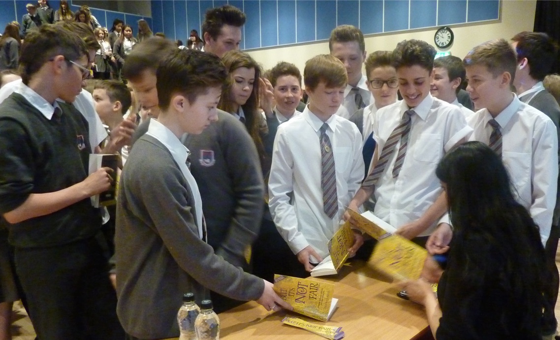 Pupils receiving the gold edition of But It's Not Fair at a school event